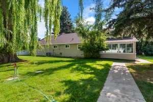 Rear view of property with a yard