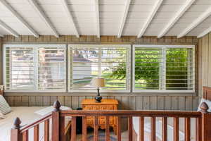 Sunroom featuring lofted ceiling with beams