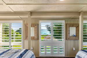 Bedroom featuring multiple windows and wooden walls