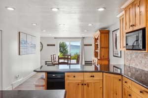 Kitchen with a textured ceiling, kitchen peninsula, and hardwood / wood-style floors