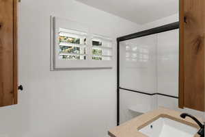 Bathroom featuring walk in shower, toilet, vanity, and a textured ceiling