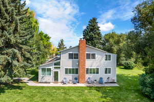 Back of house with a patio area and a lawn