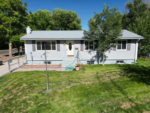 Ranch-style home featuring a front lawn