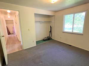 Unfurnished bedroom with carpet, a closet, and a textured ceiling