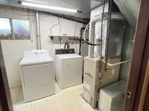 Laundry room with washer and dryer and light tile patterned linoleum floors