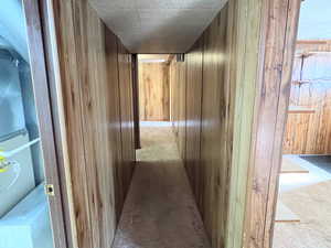 Corridor with wood walls and light carpet