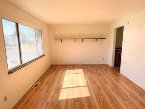 Unfurnished room with light LVP / wood-style floors