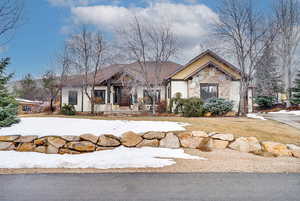 View of front facade with stone siding and covered porch