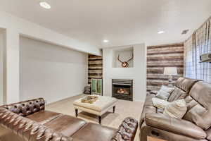 Carpeted living room with wooden walls and a textured ceiling