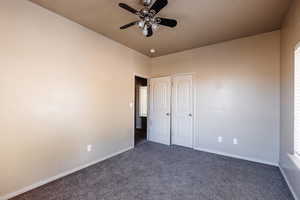 Unfurnished bedroom featuring ceiling fan and carpet flooring