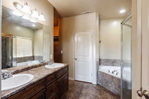 Bathroom featuring plus walk in shower, tile patterned floors, and double sink vanity