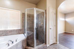 Bathroom with independent shower and bath, wood-type flooring, and a textured ceiling