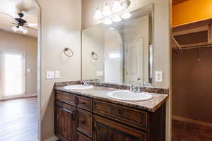 Bathroom featuring hardwood / wood-style flooring, ceiling fan, and double vanity