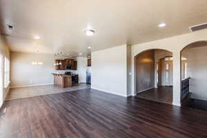 Unfurnished living room with a notable chandelier and hardwood / wood-style floors