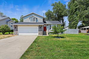 View of front facade featuring a garage and a front lawn