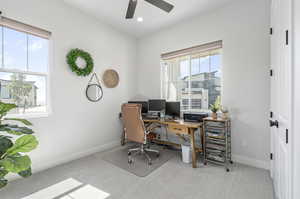 Home office with plenty of natural light, carpet floors, and ceiling fan