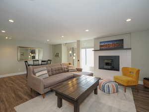 Living room featuring a tile fireplace, an AC wall unit, and wood-type flooring