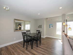 Dining space with dark hardwood / wood-style floors and a wall mounted air conditioner