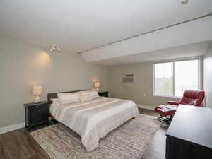 Bedroom featuring a wall mounted AC and hardwood / wood-style flooring