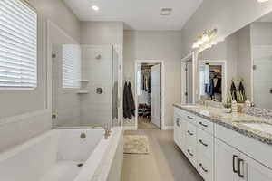 Bathroom featuring tile patterned flooring, plus walk in shower, and dual bowl vanity