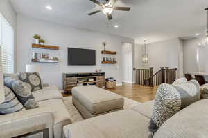 Living room with light hardwood / wood-style flooring and ceiling fan