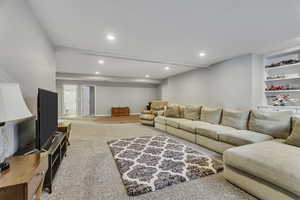 Living room with built in shelves and light carpet