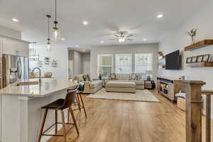 Living room with sink, light wood-type flooring, and ceiling fan