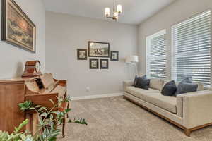 Living area featuring an inviting chandelier and carpet floors