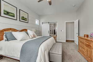 Bedroom with hardwood / wood-style flooring, a barn door, and ceiling fan