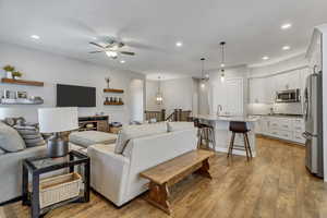 Living room with sink, ceiling fan, and light hardwood / wood-style floors