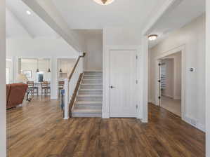 Stairs with beam ceiling and hardwood / wood-style flooring