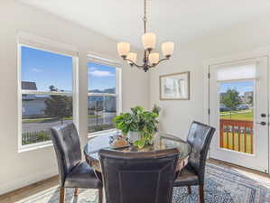 Dining area featuring hardwood / wood-style flooring, a notable chandelier, and a wealth of natural light