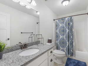 Full bathroom featuring vanity, tile patterned flooring, toilet, and shower / bath combination with curtain