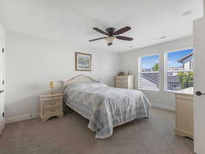 Carpeted bedroom with ceiling fan