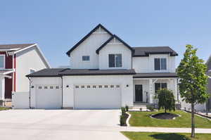 View of front of property with a garage and a front yard