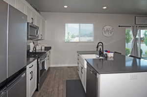 Kitchen featuring plenty of natural light, white cabinetry, and stainless steel appliances