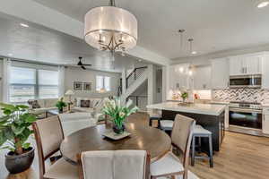 Dining area featuring light hardwood / wood-style floors and ceiling fan with notable chandelier