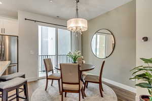 Dining space featuring an inviting chandelier, light wood-type flooring, and a wealth of natural light