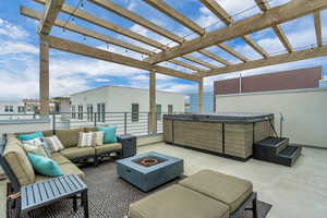 View of patio / terrace featuring a pergola, an outdoor living space with a fire pit, and a hot tub