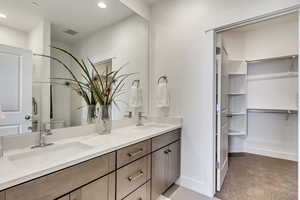 Bathroom featuring toilet and dual bowl vanity