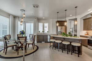 Dining space with sink, a textured ceiling, and light tile patterned floors