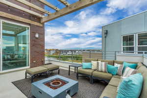 View of patio with a balcony, a mountain view, and an outdoor living space with a fire pit