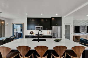 Kitchen with appliances with stainless steel finishes, decorative light fixtures, sink, and a chandelier