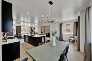 Dining room featuring light wood-type flooring, a notable chandelier, and sink