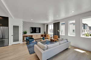 Living room with light wood-type flooring and a healthy amount of sunlight