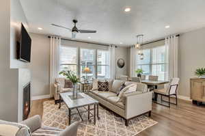 Living room with light hardwood / wood-style floors and ceiling fan