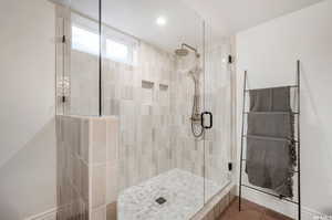 Bathroom with a shower with shower door and tile patterned flooring