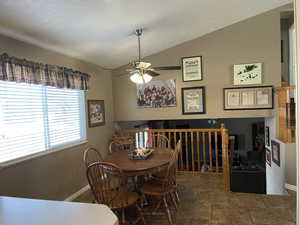 Tiled dining area with lofted ceiling and ceiling fan