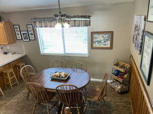 Dining room with dark tile patterned floors and ceiling fan