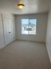 Carpeted spare room featuring a textured ceiling